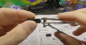 Using fingernail clippers to remove a plastic burr left by the sprue on a TT-02 part