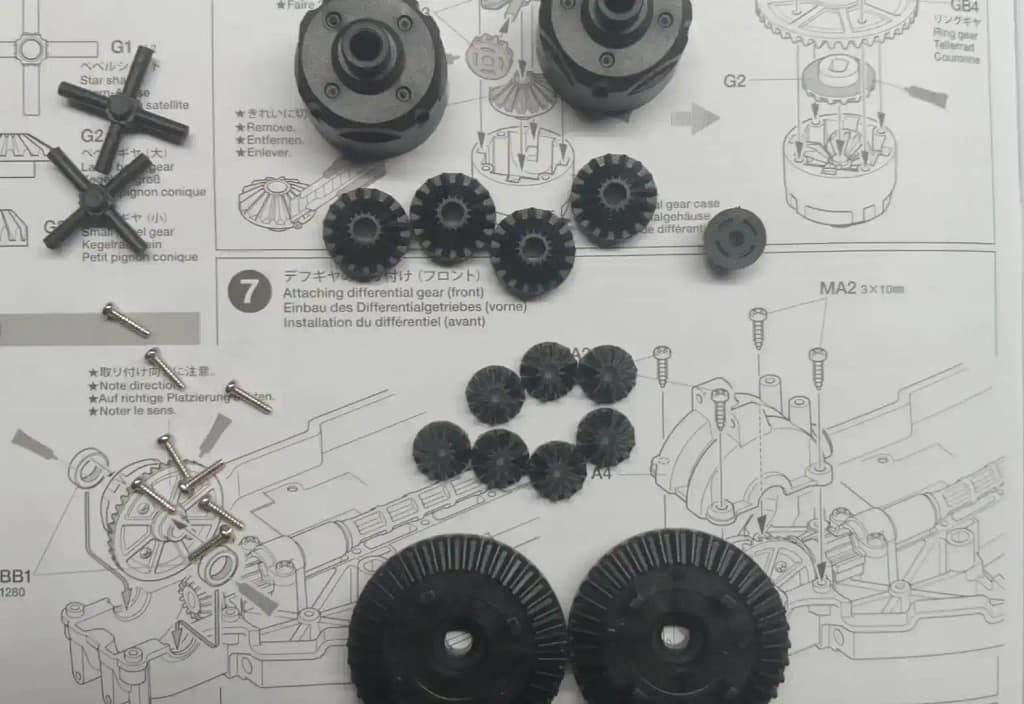 Tamiya TT-02 differential assembly parts including bevel gears, ring gears, differential housing, screws, and differential shaft