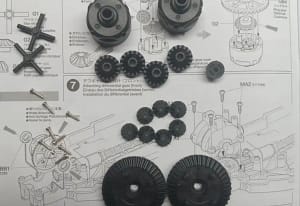 Tamiya TT-02 differential assembly parts including bevel gears, ring gears, differential housing, screws, and differential shaft